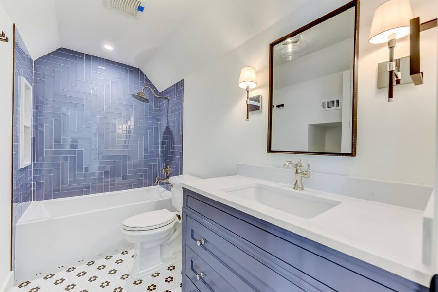 Full bathroom featuring visible vents, toilet, vanity, and vaulted ceiling