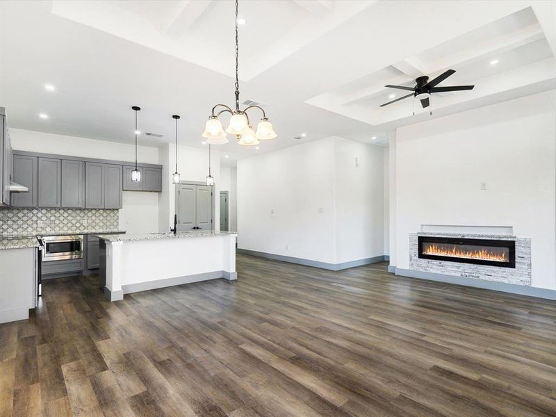 Kitchen featuring decorative light fixtures, open floor plan, dark wood finished floors, tasteful backsplash, and beam ceiling Kitchen featuring decorative light fixtures, open floor plan, dark wood finished floors, tasteful backsplash, and beam ceiling