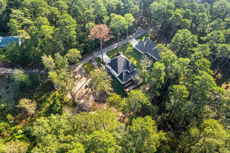 This aerial photo showcases a beautifully secluded home surrounded by lush greenery and tall trees, offering privacy and a serene natural setting. The house features a spacious yard and is located along a quiet road, perfect for those seeking tranquility. This aerial photo showcases a beautifully secluded home surrounded by lush greenery and tall trees, offering privacy and a serene natural setting. The house features a spacious yard and is located along a quiet road, perfect for those seeking tranquility.