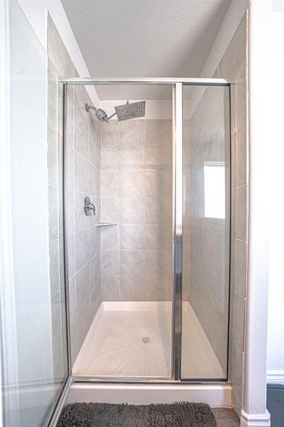 Full bath with a stall shower and a textured ceiling