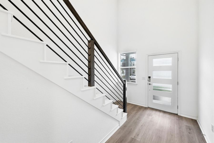 Foyer entrance featuring stairs and light wood-style floors