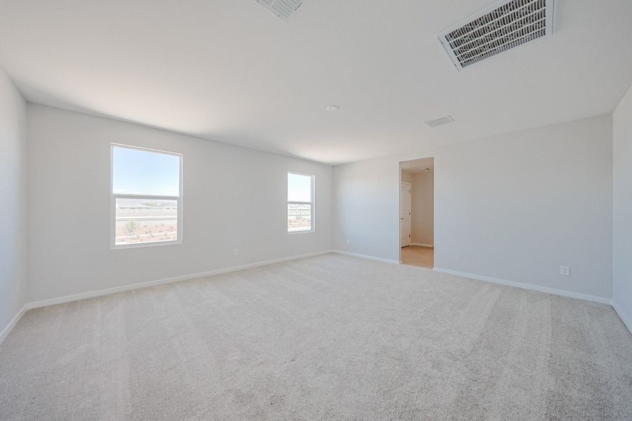 A room with a carpet and windows.