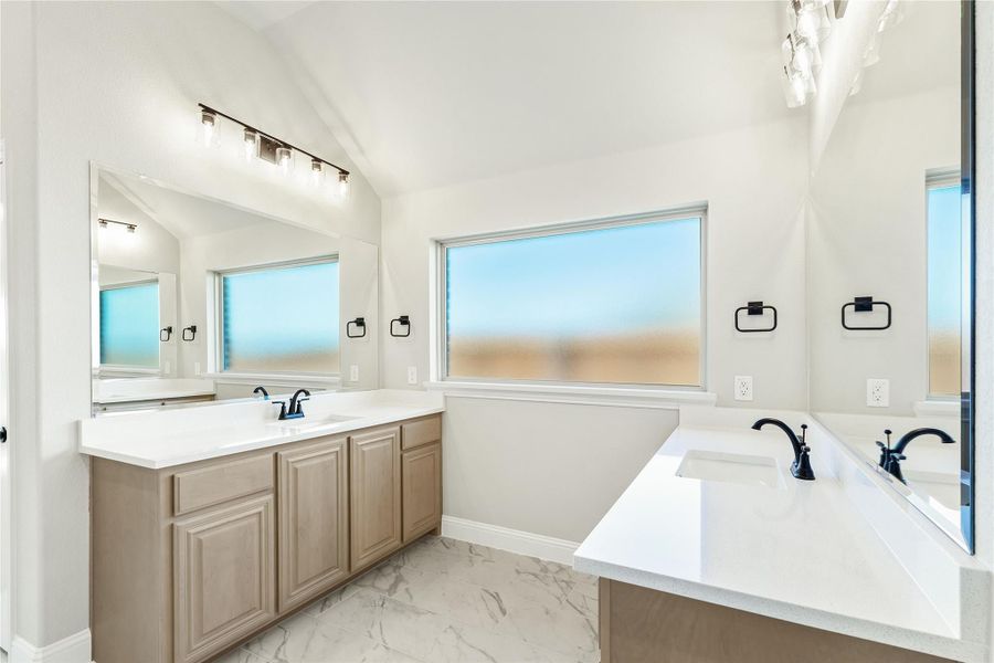 Master bathroom with double vanity, soaking tub, white quartz countertops, and marble tile floors Master bathroom with double vanity, soaking tub, white quartz countertops, and marble tile floors