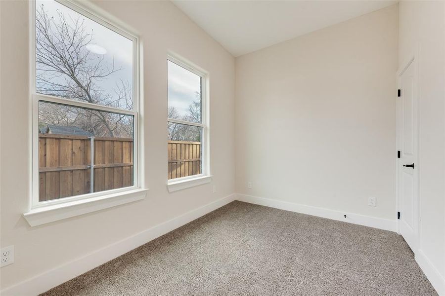 Carpeted empty room featuring baseboards