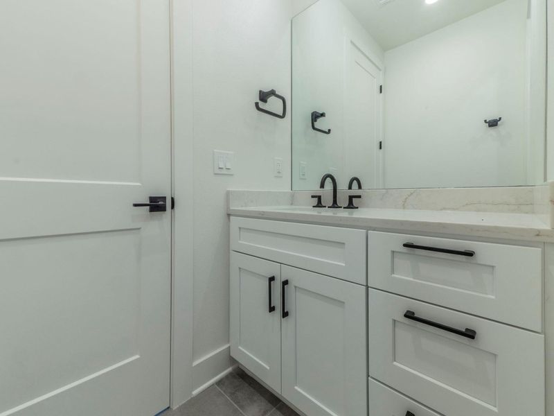 Bathroom with vanity and dark tile patterned floors Bathroom with vanity and dark tile patterned floors