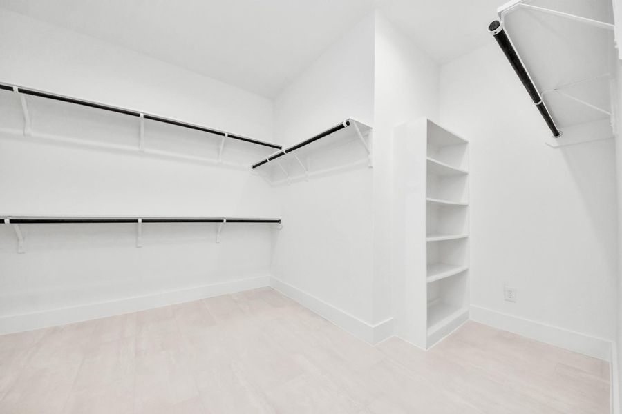 Walk-in closet that epitomizes luxury and practicality. This generously sized space features built-in shelving, offering abundant room for impeccable organization. High ceilings and recessed lighting create a bright and welcoming ambiance. Walk-in closet that epitomizes luxury and practicality. This generously sized space features built-in shelving, offering abundant room for impeccable organization. High ceilings and recessed lighting create a bright and welcoming ambiance.