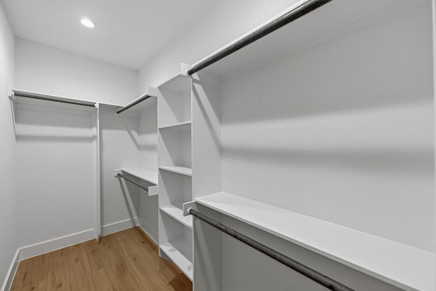 Walk in closet with light wood finished floors