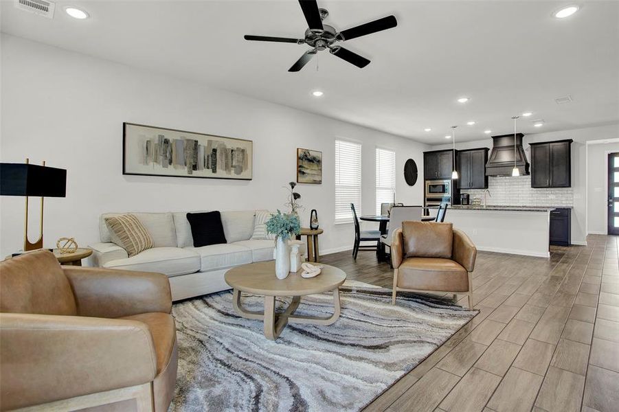 Living room with ceiling fan and hardwood / wood-style flooring