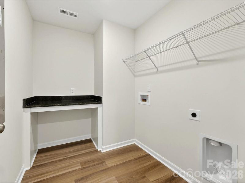 Laundry features folding table with granite countertop