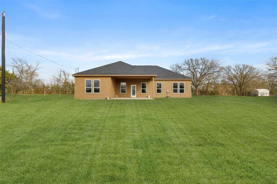 Back of house with a lawn and a patio area