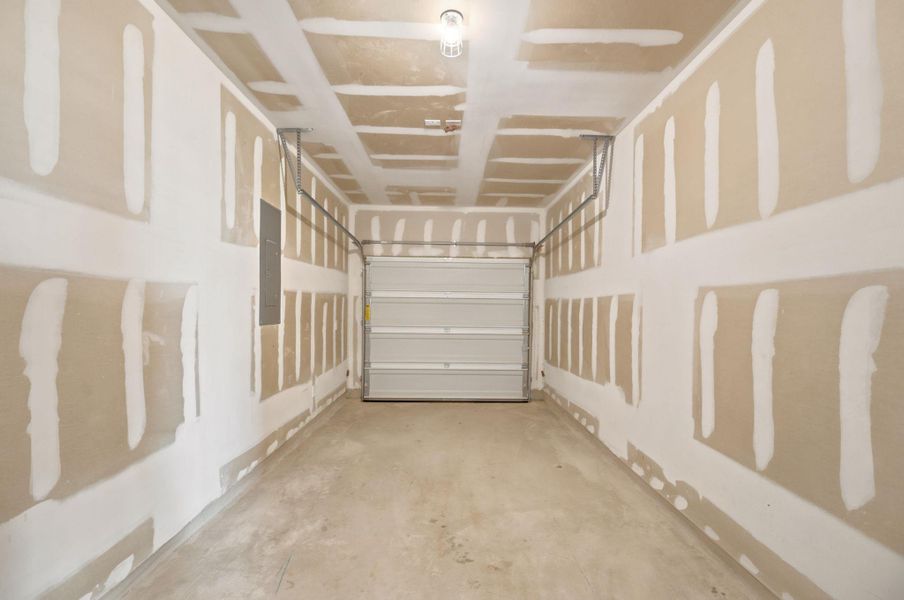 Unfinished drywall outlines this functional one car garage with solid concrete flooring.
