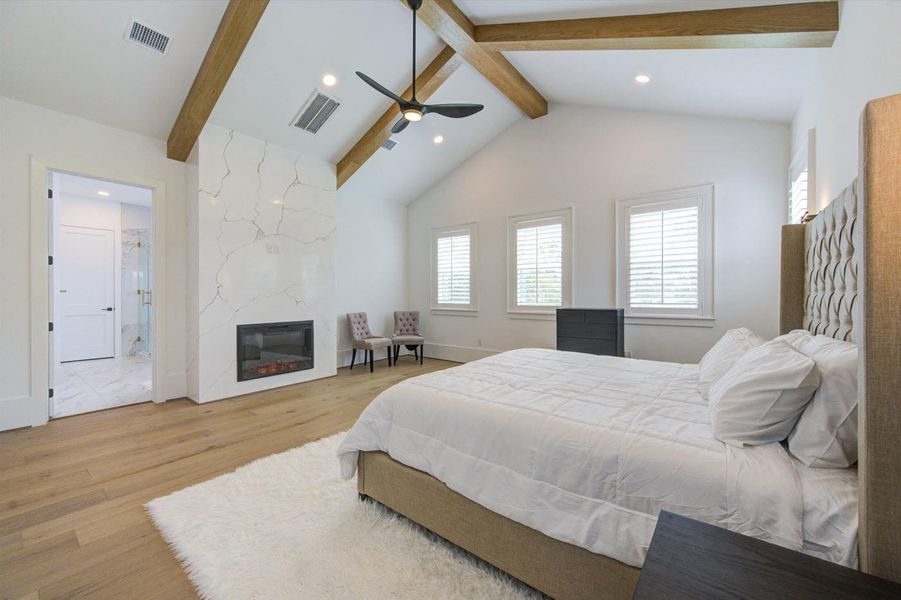 Primary bedroom with fireplace and TV stand ready to accommodate any size screen.