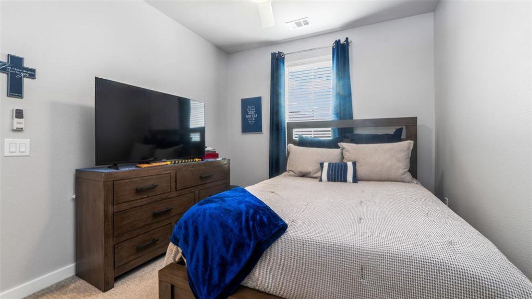 Carpeted bedroom with ceiling fan