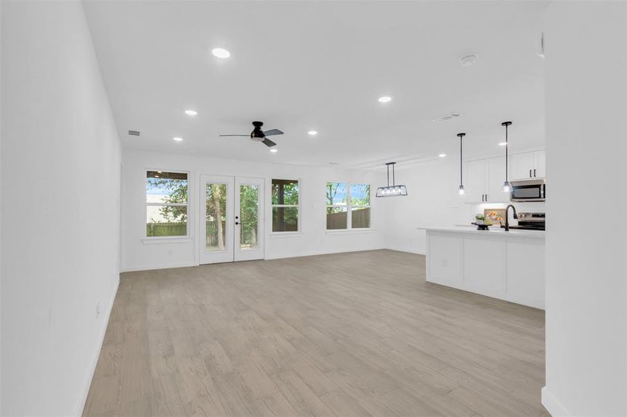 Unfurnished living room with recessed lighting, a ceiling fan, plenty of natural light, and light wood finished floors
