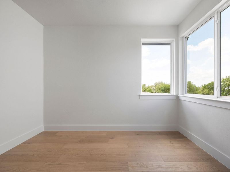 Hardwood floors and generous windows create an airy, naturally illuminated space perfect for relaxation.