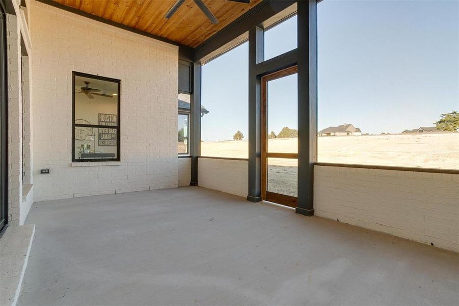 Unfurnished sunroom with ceiling fan and wooden ceiling