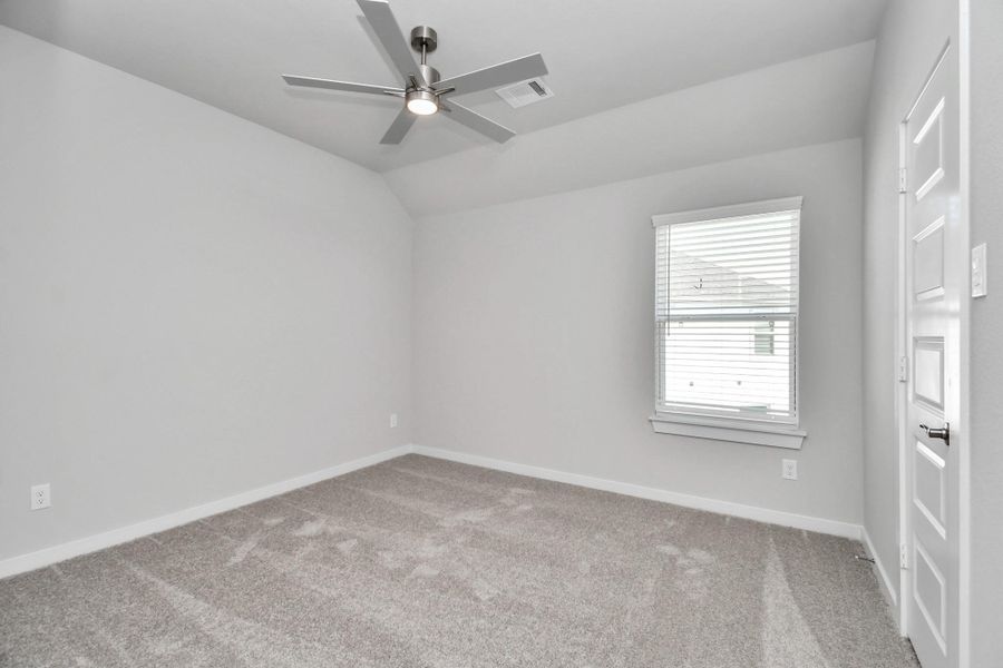 Secondary bedroom features plush carpeting, large windows that let in plenty of natural light, bright paint, and spacious closets. Sample photo of completed home with similar floor plan. Actual colors and selections may vary.