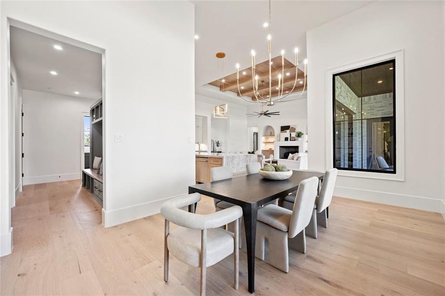 Dining area with light wood-type flooring, a fireplace, recessed lighting, and ceiling fan