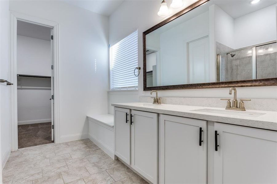 Primary Bathroom with double sink vanity an oversized shower with door & window seat