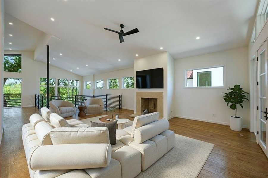Living room featuring plenty of natural light, recessed lighting, ceiling fan, wood finished floors, and a fireplace