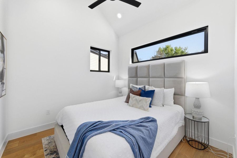 Bedroom with wood finished floors, vaulted ceiling, ceiling fan, and recessed lighting