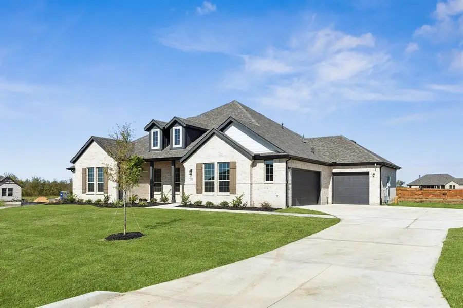 View of front of home with brick siding, driveway, a front yard, an attached garage, and roof with shingles