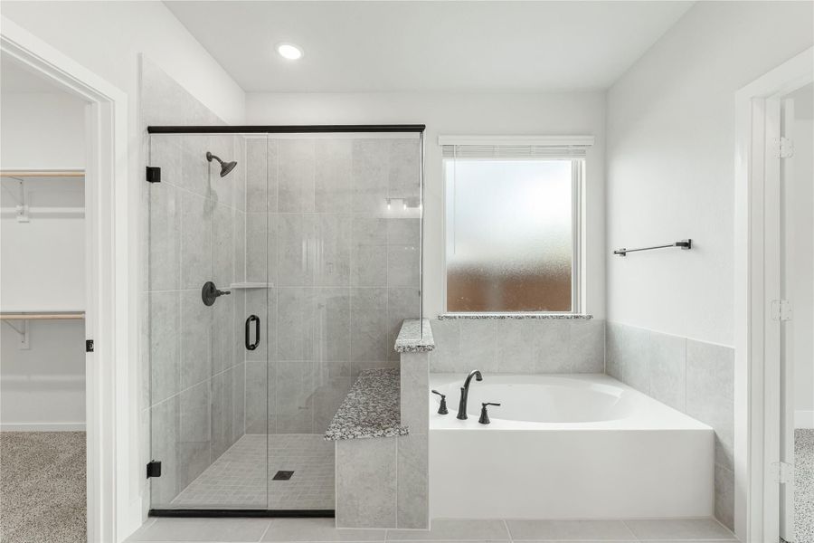 Master bathroom with glass-enclosed walk-in shower, soaking tub, and gray tile walls