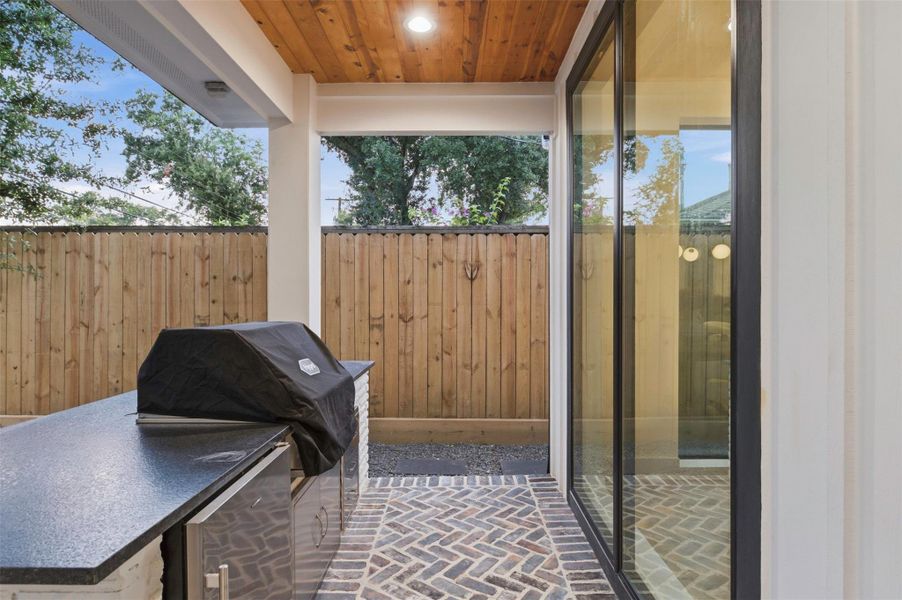 Outdoor kitchen provides a built-in entertaining space complete with a beverage refrigerator.