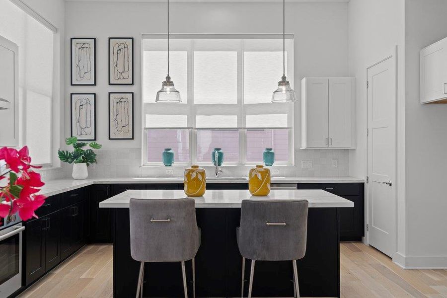 A well-appointed kitchen features a central island, ample cabinetry, and sleek countertops. A well-appointed kitchen features a central island, ample cabinetry, and sleek countertops.
