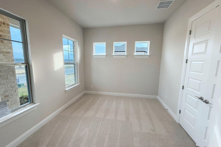 Unfurnished room featuring light carpet and baseboards