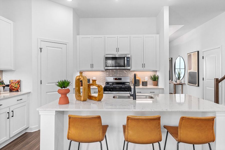 A kitchen with white cabinets.
