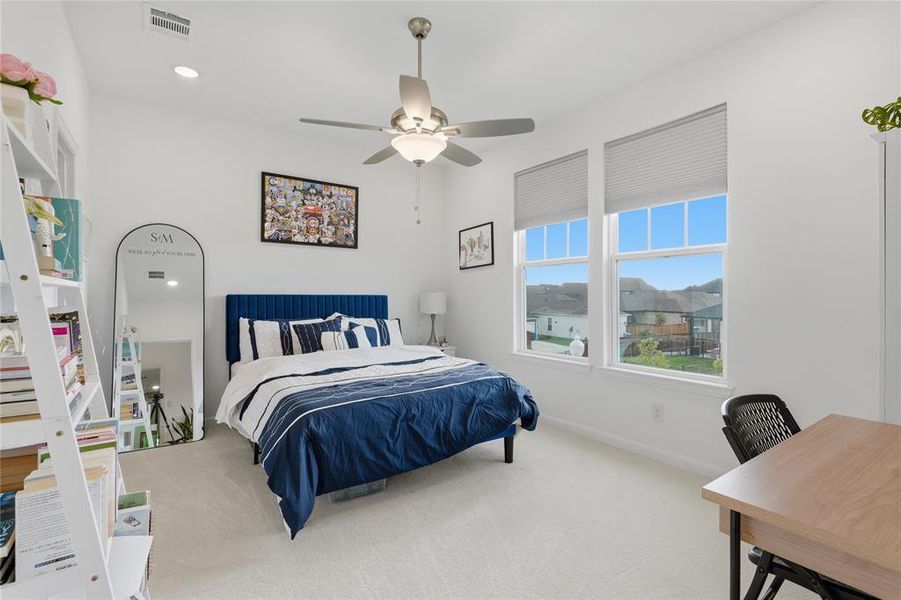 Bright bedroom featuring white walls and neutral carpet flooring Bright bedroom featuring white walls and neutral carpet flooring