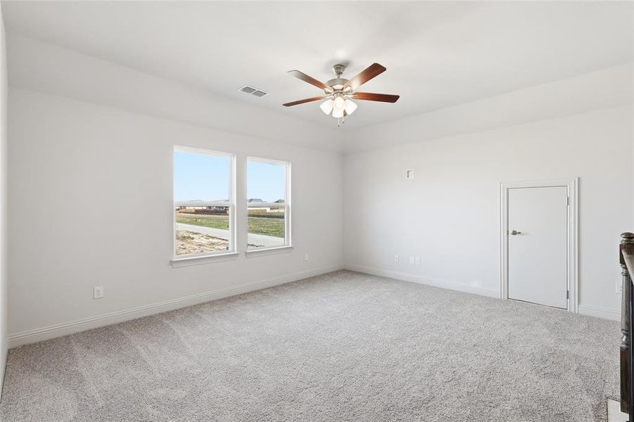 Spare room featuring light colored carpet and a ceiling fan Spare room featuring light colored carpet and a ceiling fan