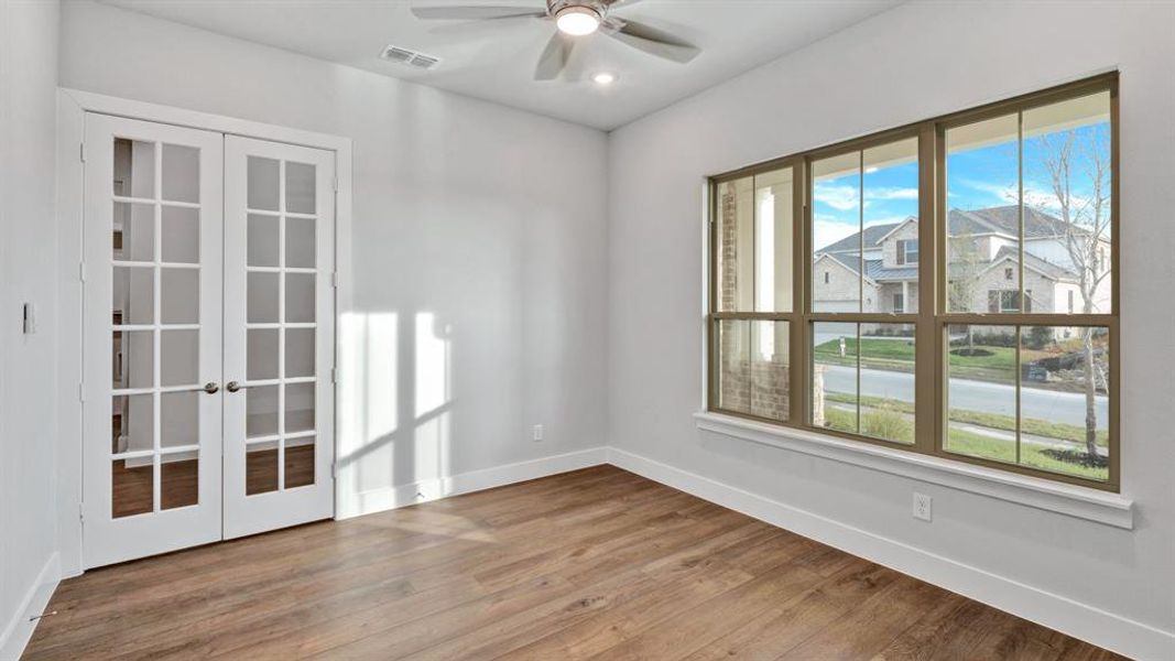 Empty room with french doors, hardwood / wood-style flooring, and ceiling fan