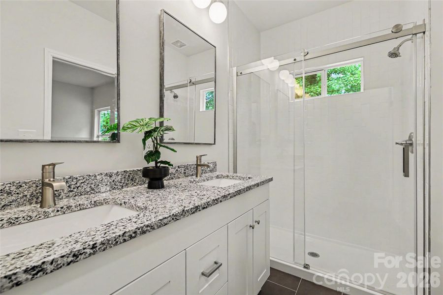 Primary En Suite granite counter tops with glass sliding shower doors