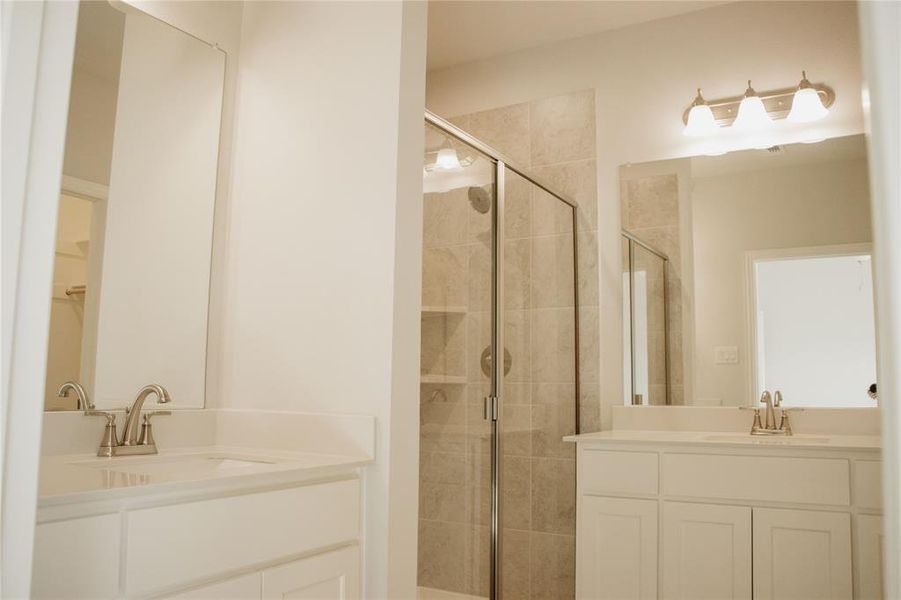 Bathroom featuring walk in shower and vanity