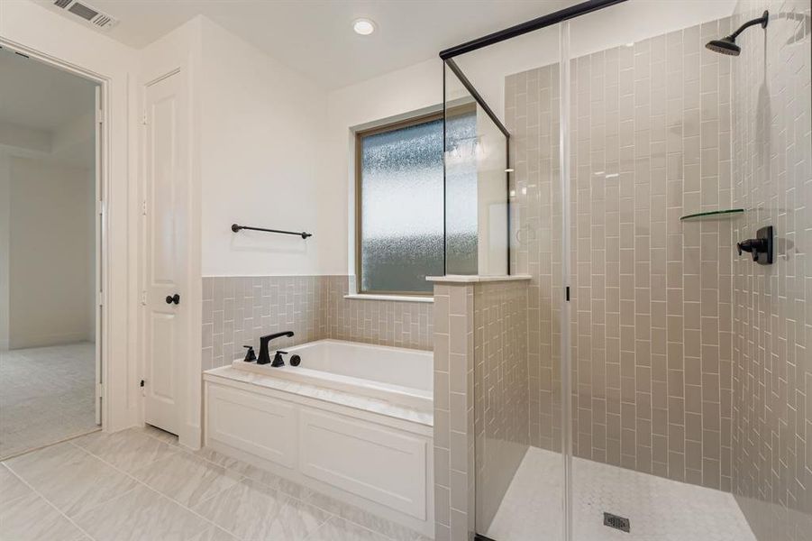 Full bath featuring a shower stall, a bath, recessed lighting, tile walls, and light tile patterned flooring Full bath featuring a shower stall, a bath, recessed lighting, tile walls, and light tile patterned flooring