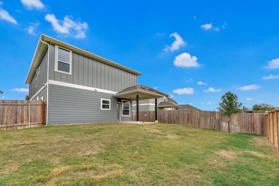 Back of house featuring a patio area, board and batten siding, and a fenced backyard