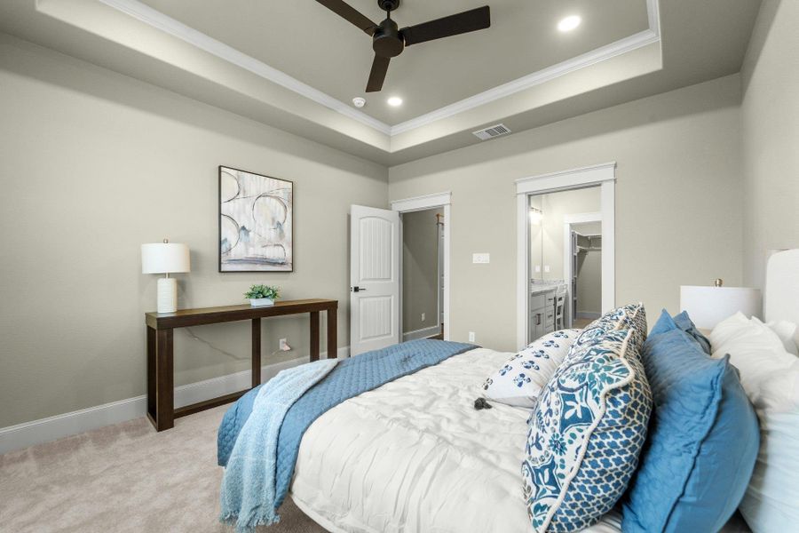 Bedroom featuring a tray ceiling with recessed lighting and a ceiling fan