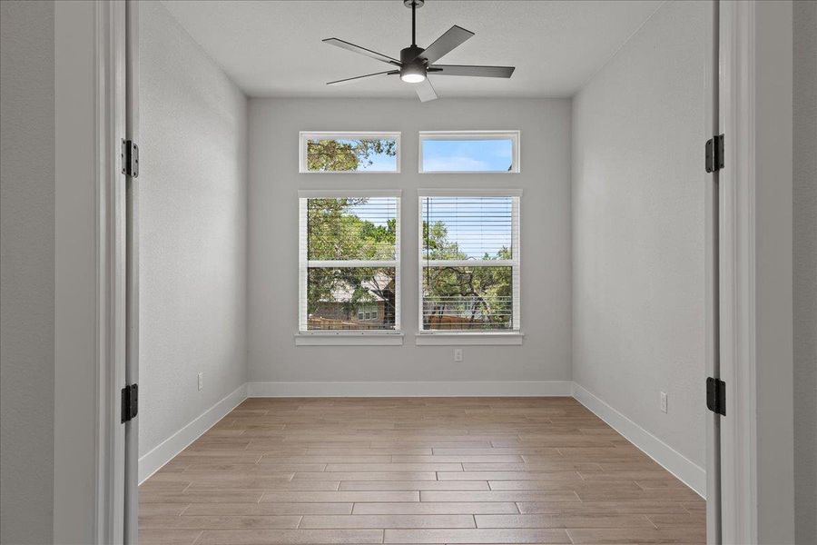 Unfurnished room featuring light wood-type flooring and ceiling fan Unfurnished room featuring light wood-type flooring and ceiling fan