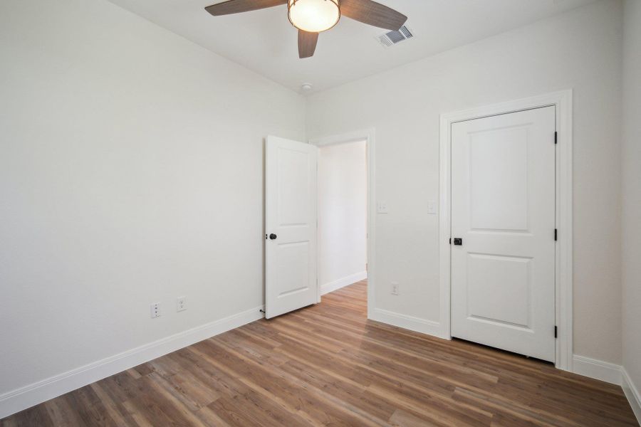 Bedroom 2 with a ceiling fan, wood finished floors, baseboards, and visible vents Bedroom 2 with a ceiling fan, wood finished floors, baseboards, and visible vents