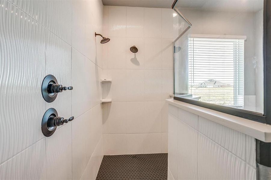 Bathroom with tiled shower and tile walls