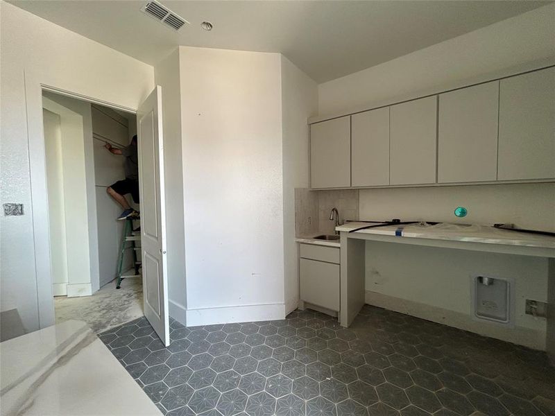 The utility room, conveniently located near the kitchen, offers ample space for laundry and storage needs.