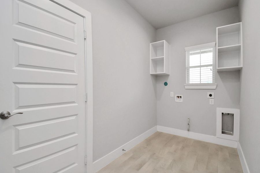 A perfect blend of functionality and comfort. Capture the essence of easy living with a first-floor laundry room, thoughtfully equipped with shelving for effortless organization. Sample photo of completed home with similar floor plan. Actual colors and selections may vary. A perfect blend of functionality and comfort. Capture the essence of easy living with a first-floor laundry room, thoughtfully equipped with shelving for effortless organization. Sample photo of completed home with similar floor plan. Actual colors and selections may vary.