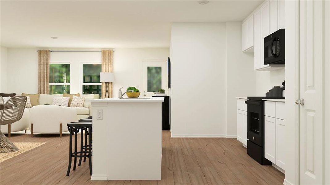 Kitchen with a kitchen breakfast bar, light hardwood / wood-style flooring, black appliances, and white cabinets