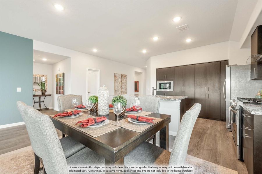 Dining area with dark wood table and chairs, open to kitchen with dark cabinets and stainless steel appliances Dining area with dark wood table and chairs, open to kitchen with dark cabinets and stainless steel appliances