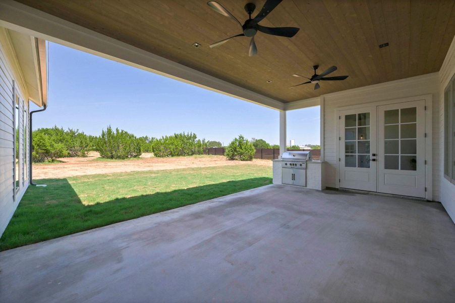 View of patio with ceiling fan, area for grilling, and french doors