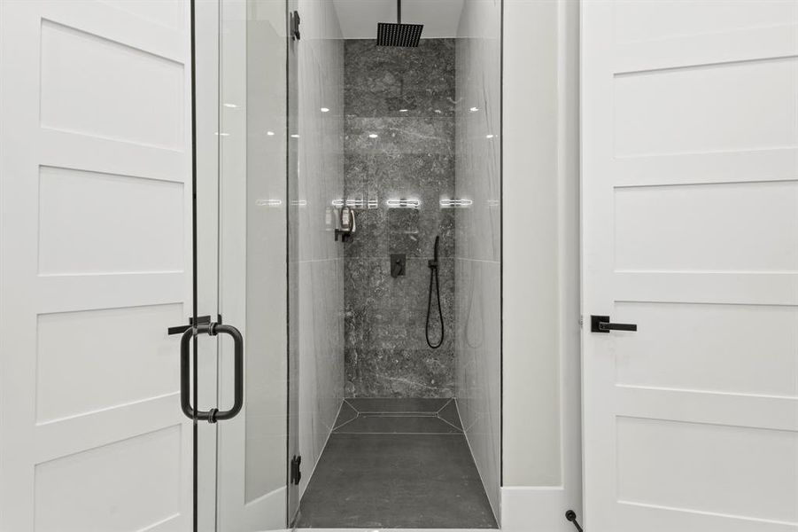 Full bath with a marble finish shower