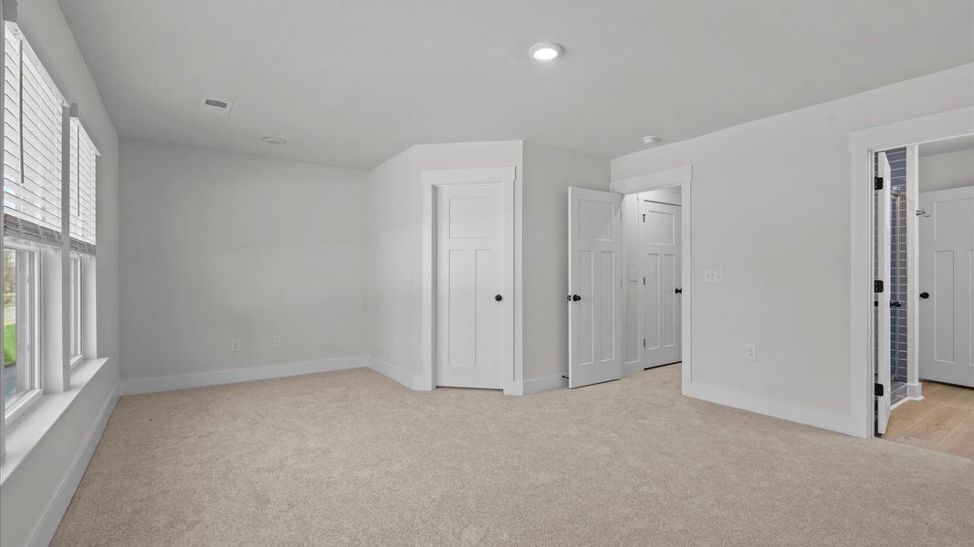 Eye-catching details and elegant finishes in the vibrant primary suite of this select townhome at Gresham Station