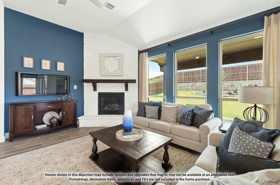 Living room with white brick fireplace, blue accent walls, beige sofa, and large windows overlooking backyard Living room with white brick fireplace, blue accent walls, beige sofa, and large windows overlooking backyard